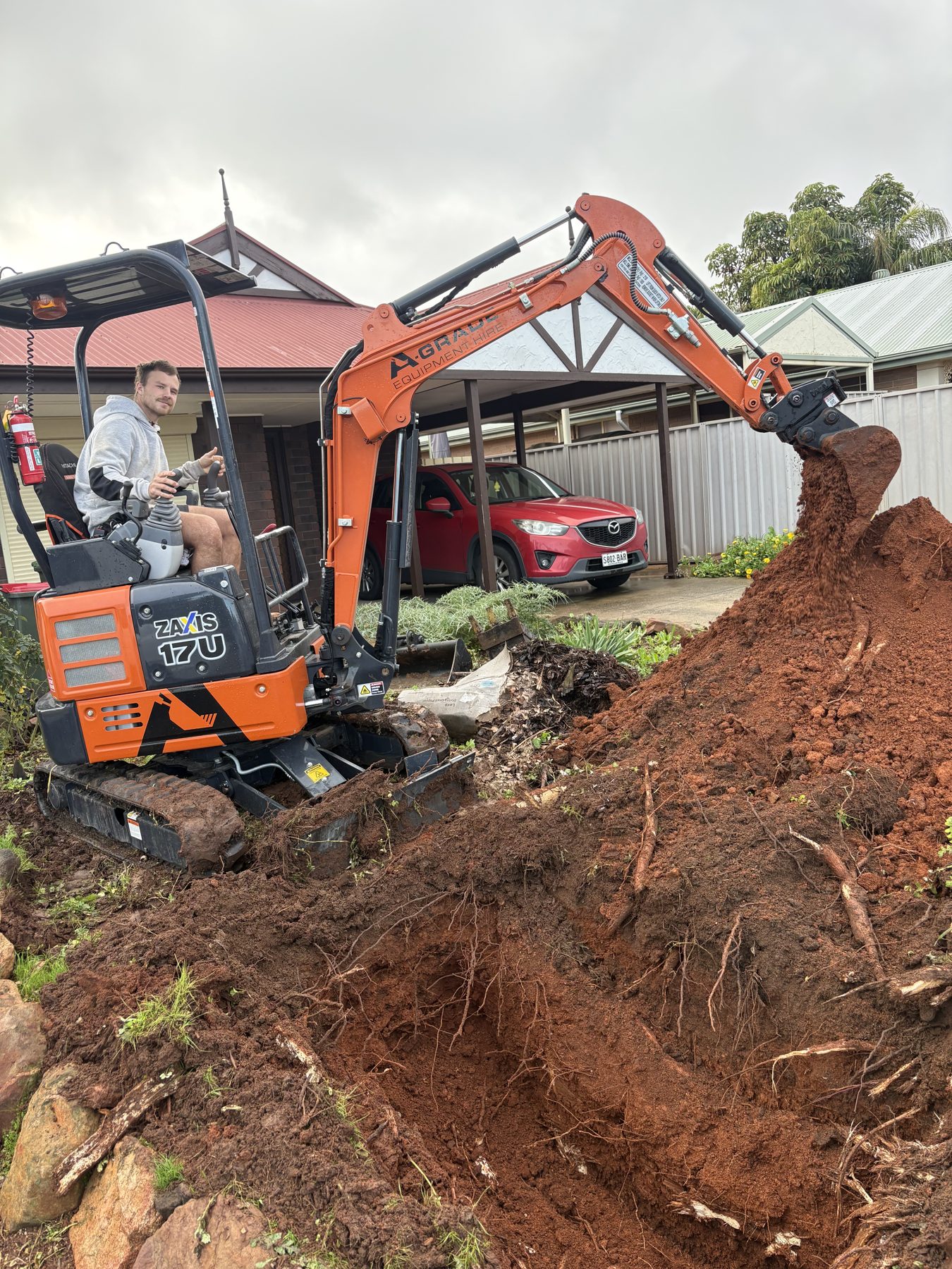 Stump removal in a backyard with a mini excavator